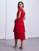 Vestido blanco de gasa con capas, marca Julia Jordan. Escote en V, manga corta con volados, corte en cintura y abertura central en espalda con cierre invisible.