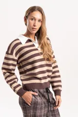Buzo de punto con diseño a rayas horizontales en tonos marrón y beige. Presenta un cuello polo en color blanco con cierre frontal de botones, mangas largas con puños acanalados y un corte holgado tipo boxy.