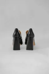 Mocasines color beige con estampado de piel de cocodrilo, plataforma y tacón cuadrado.