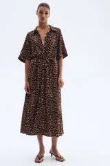 Vestido midi con estampado de leopardo, cuello camisero, manga corta y botonadura frontal. Presenta elástico en la cintura y cinturón extraíble para atar.