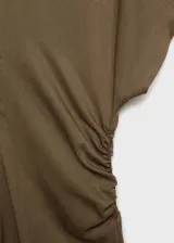 Vestido midi de tejido fluido con diseño evasé, escote en pico y mangas cortas. Presenta un detalle drapeado en los laterales de la cintura y cierre de cremallera invisible en la parte posterior.