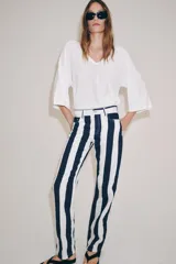 Jeans de tiro medio de corte slim, con diseño de rayas verticales a contraste en color azul marino y blanco. Cuenta con cinco bolsillos, trabillas para cinturón y cierre frontal con cremallera y botón metálico.