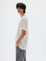 Remera gris oscura de algodón lavado, con cuello redondo, manga corta y corte oversize. Presenta un pequeño logo bordado en el pecho.