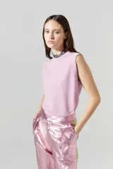 Top tejido de punto color rosa con lúrex, sin mangas y cuello a la base.