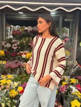 Sweater de tejido de punto de algodón con diseño rayado en color blanco, bordó y rosado, cuello redondo a la base, mangas largas acampanadas y silueta oversize.