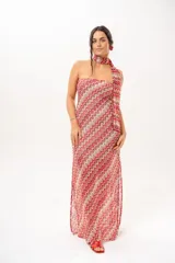 Vestido largo de crochet con escote strapless y lazo integrado para el cuello, con diseño de patrón en zigzag en tonos rojos, blancos y beige, y aberturas laterales en la falda.