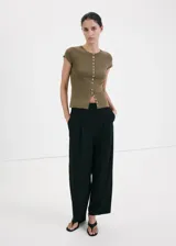 Chaleco de punto fino color verde militar, con cuello redondo, manga corta y cierre frontal completo con botones nacarados.