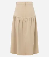 Pollera midi color beige confeccionada en sarga de algodón certificado BCI, con cintura alta y pasadores, bolsillos frontales, recorte en la cadera con frunces y cierre de botón y cremallera.