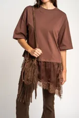 Remera oversize marrón con corte a la altura de la cadera, cuello redondo y mangas cortas holgadas. Incorpora un aplique inferior superpuesto de satén con detalles de encaje bordado en los bordes.
