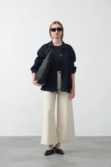 Remera de tejido acanalado color blanco, con cuello redondo y mangas cortas que presentan un detalle de terminación en puntilla en los bordes.