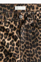 Bermuda de cinco bolsillos en denim de algodón rígido, con tiro alto, cierre y botón, y estampado animal print de leopardo.
