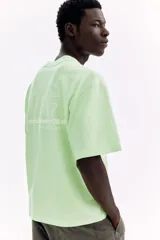 Remera de algodón verde menta de punto pesado, con corte holgado, hombros caídos, cuello redondo y estampa numérica frontal.
