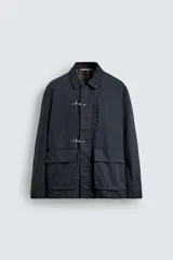 Parka de corte relajado confeccionada en mezcla de algodón. Presenta cuello solapa, cierre frontal con cremallera oculta y alamares metálicos, bolsillos de plastrón con solapa en la cadera y bolsillo de vivo en el pecho.