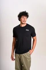 Remera de algodón negra con cuello redondo y mangas cortas. Presenta el logo de la marca estampado en blanco en el lado izquierdo del pecho.