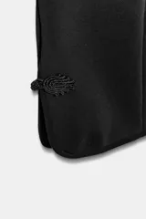 Pantalón capri negro de tiro medio con cintura elástica y detalle de alamares en el bajo.
