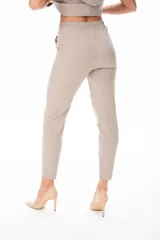 Pantalón de vestir color beige, con corte recto, bolsillos laterales y cinturón con hebilla metálica.