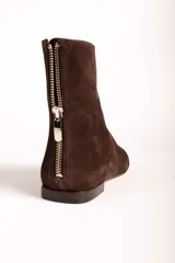 Botas cortas de gamuza color marrón, con punta cuadrada y cierre lateral. Diseño minimalista con costura central vertical.