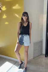 Short de jean de tiro alto con diseño color block, una pierna en denim azul y la otra en denim blanco.