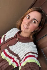 Saco tejido de punto con diseño de ochos, con bloques de color en marrón, blanco, rojo y amarillo neón. Presenta mangas largas y cierre frontal con botones.