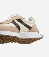 Championes estilo jogging con diseño de paneles en tonos gris, blanco y negro. Presentan cierre por cordones, suela de goma con relieve que se extiende hacia el talón y acabado en poliuretano.