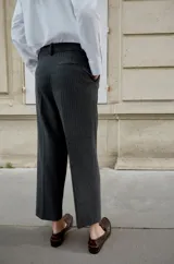 Pantalón de tiro medio con pinzas delanteras y pernera recta. Cuenta con bolsillos frontales, falsos bolsillos traseros de vivo y cierre frontal con cremallera, botón interior y ganchos.