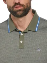 Polo de piqué color verde oliva con diseño jacquard y logo de pingüino bordado en el pecho. Cuello y mangas con ribete liso.