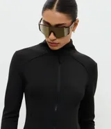 Campera deportiva Get Over de ajuste entallado, confeccionada en microfibra con malla térmica. Presenta cuello alto, cierre frontal con cremallera, mangas largas con orificio para pulgar y bolsillos laterales con cierre.