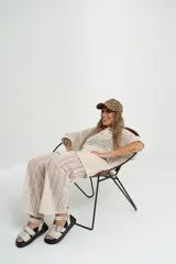 Pantalón de tejido calado color crudo, con cintura elástica y corte palazzo.