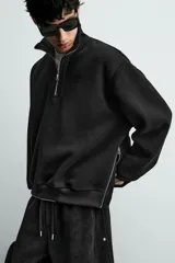 Sudadera de corte relajado confeccionada en pana con interior de tejido polar. Presenta cuello subido con cierre frontal de cremallera, manga larga y acabados en rib. Incluye bajo ajustable con cremalleras laterales.