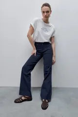 Pantalón de jean azul marino, de tiro alto y calce ajustado con pierna recta levemente amplia, bolsillos traseros y recortes verticales en el delantero.