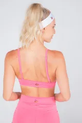 Top deportivo rosa con tiras regulables y desmontables para usarlo de tres formas distintas.