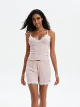 Conjunto de pijama compuesto por una musculosa de breteles finos con detalle de encaje en el escote y un short con terminación de encaje en el ruedo. Ambas prendas están confeccionadas en tejido acanalado.