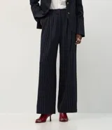 Pantalón de sastrería corte wide leg, color azul marino con estampa de rayas finas. Presenta cintura con pasantes, pinzas frontales y bolsillos traseros.