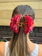 Pinza para el pelo con flores rojas de tela.