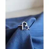 Anillo de plata 925 con diseño de corazón calado adornado con pequeñas zirconias brillantes.