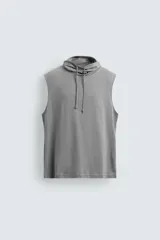 Camiseta sin mangas de corte relajado, confeccionada en algodón ligero, con cuello subido ajustable mediante cordones.