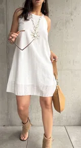 Vestido corto blanco con bordado calado, tirantes finos y corte recto.