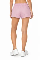 Short de poliamida negro, holgado, de tiro bajo, con bolsillos laterales y cordón ajustable en la cintura.