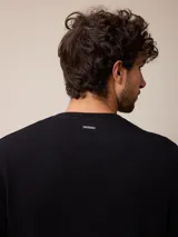 Sweater de punto con cuello redondo, manga larga y puños acanalados. Presenta un pequeño logo bordado en el pecho.