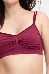 Soutien tipo bralette de microfibra sin costuras, con diseño de doble bretel regulable y detalle fruncido en el centro del escote. Cuenta con cierre de broche doble en la espalda con tres niveles de ajuste.