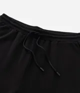 Pantalón jogger de pijama color negro, confeccionado en tejido de modal con mezcla de poliéster y elastano. Presenta cintura elástica con cordón de ajuste, bolsillos laterales y puños ajustados en el ruedo.