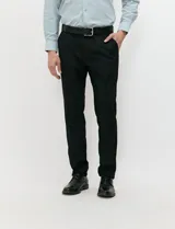 Ambo negro de corte clásico para hombre, compuesto por saco de solapas de muesca con dos botones, chaleco abotonado a juego y pantalón de vestir de corte recto.