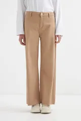 Pantalón de jean color camel, tiro alto, con corte ancho (wide leg) y ruedo deshilachado.