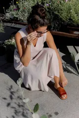 Sandalias planas de cuero marrón con tira ancha sobre el empeine. La plantilla es de cuero con la inscripción "LE".