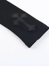 Remera de manga larga negra con cuello alto, confeccionada en viscosa y elastano. Presenta un panel frontal de encaje transparente en el pecho con un aplique de cruz bordada y detalles de cruces en las mangas.