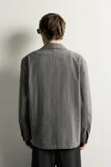 Sobrecamisa gris de corte regular fit con textura, cuello solapa, cierre frontal de botones, bolsillos de parche en el pecho y los laterales, y mangas largas con puños abotonados.
