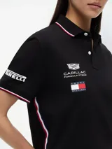 Chomba negra de algodón elástico con cuello polo, cartera de dos botones y mangas cortas. Presenta detalles de ribetes con diseño Global Stripe en el cuello y los puños, además de los logotipos de Tommy Hilfiger, TH x Cadillac Formula 1 Team, Pirelli y el número 11 en las mangas y el pecho.