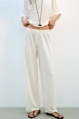 Pantalón rústico color marrón oscuro, de tiro alto, con cintura elástica y cordón ajustable, y pierna ancha.