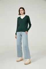 Cárdigan color beige con escote en V y cierre frontal con botones.