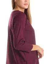 Buzo de tejido fino color violeta, con mangas tres cuartos y corte dolman. Presenta un diseño de textura geométrica sutil en el frente y cuello redondo.